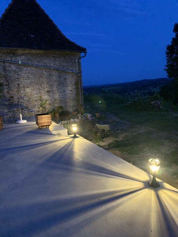 Terrasse de nuit éclairée par des luminaires au sol